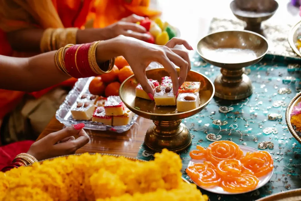 Women decorating the table with traditional sweets for Diwali