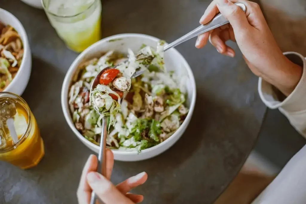 A person eating cashew coleslaw vegetable salad.