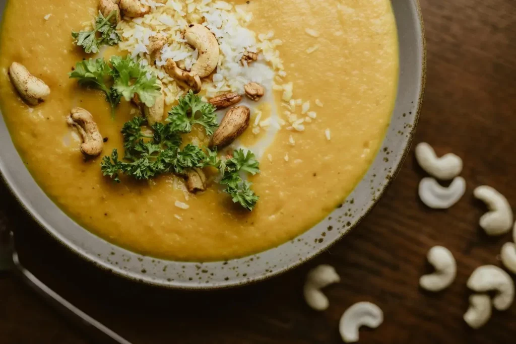 A close-up of a curry garnished with Goan cashew nuts.